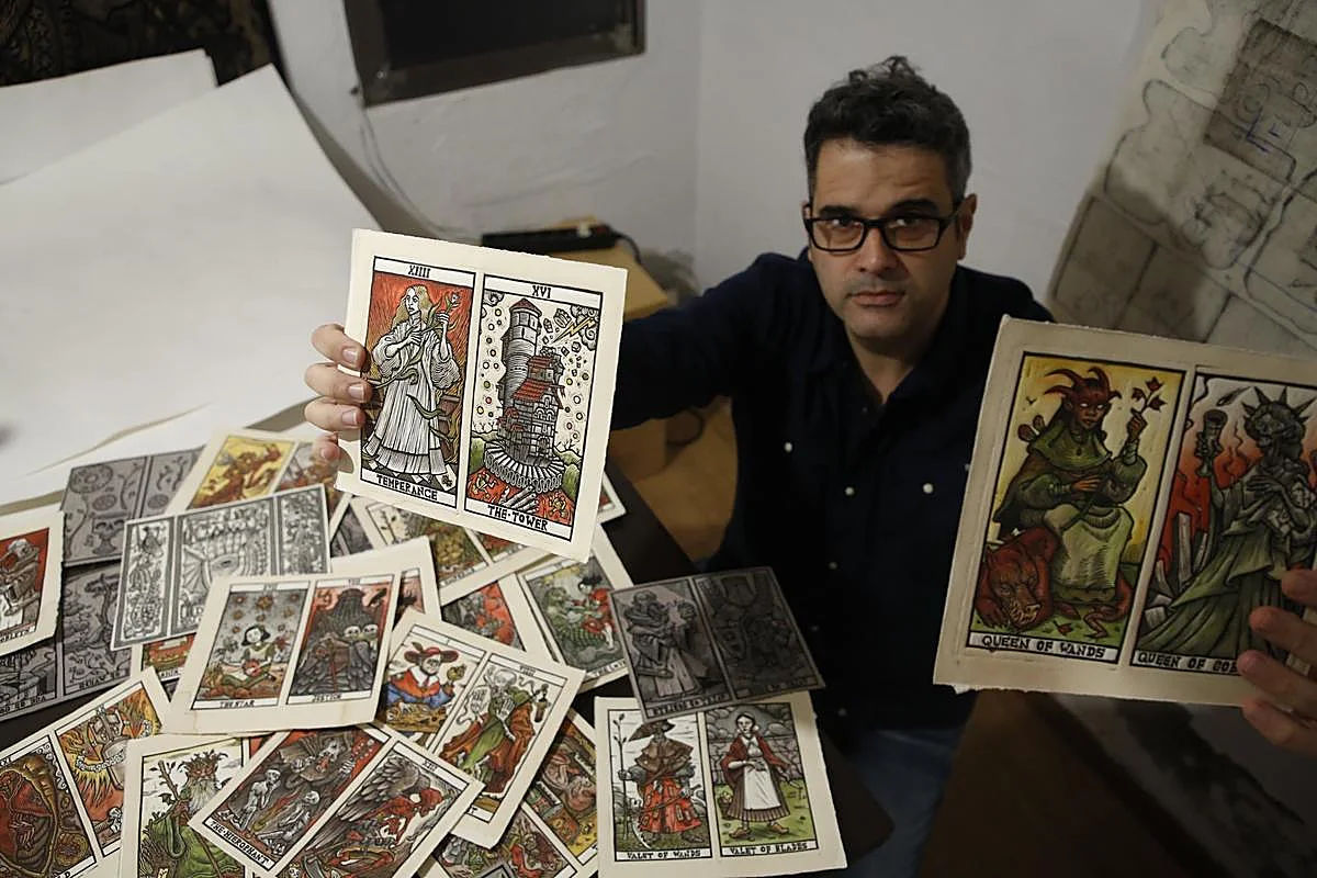 Tomás Hijo holding Tarot del Toro cards in his studio