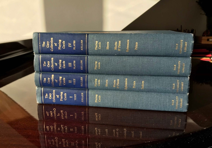 A stack of four clothbound volumes titled “The Cary Collection of Playing Cards”.