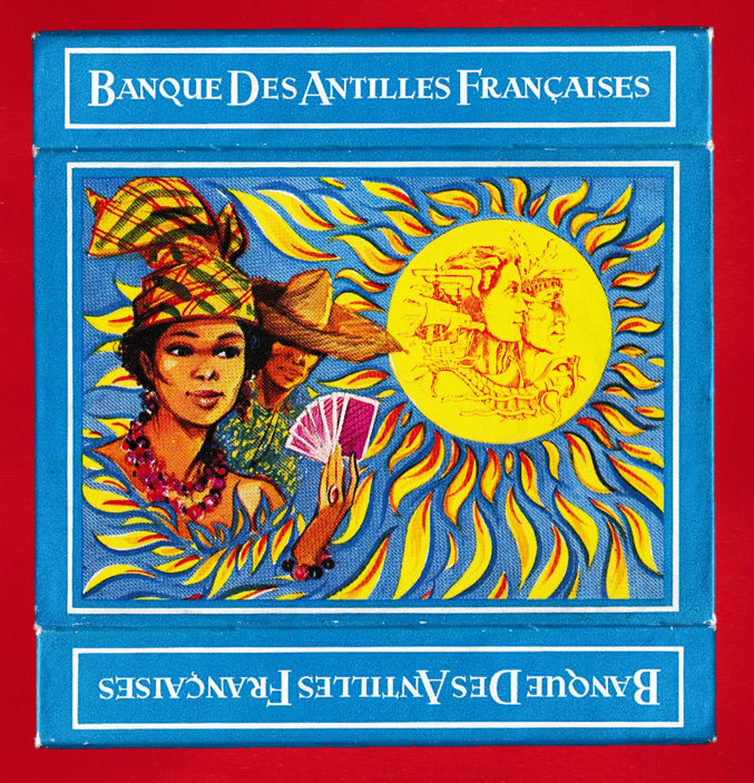 Blue double-sleeve cardboard box for the Banque des Antilles Françaises pack, with figures and a sun motif